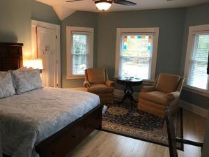 a bedroom with a bed and two chairs and a table at Greenway House Bed and Breakfast in Green Lake