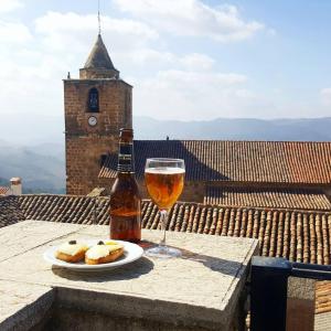 a glass of beer and a plate of food on a table at La Mesa Segureña in Segura de la Sierra