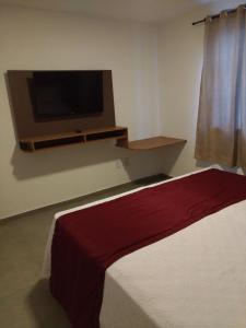 1 dormitorio con TV de pantalla plana y 1 cama en Itacuruçá Inn en Itacuruçá