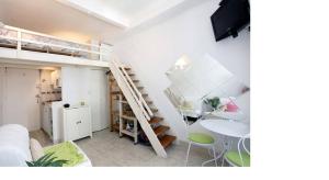 アンティーブにあるStudio- Antibes-Juan les Pins- Cote d'Azurの二段ベッド1組、テーブル、階段が備わる客室です。