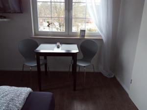 a table and two chairs in a room with a window at Landhotel Alte Mühle in Modautal