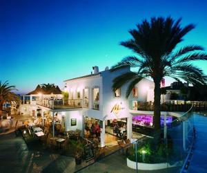 a large white building with a palm tree in front of it at Modern 2 Bed Apartment Vale do Lobo in Vale do Lobo