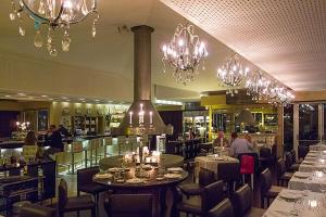 a restaurant with tables and chairs and chandeliers at Modern 2 Bed Apartment Vale do Lobo in Vale do Lobo