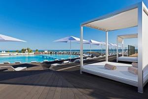 a resort with a pool with beds and umbrellas at Modern 2 Bed Apartment Vale do Lobo in Vale do Lobo