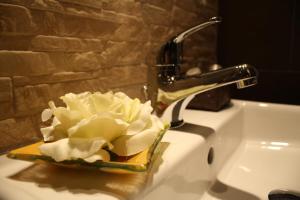 ein Waschbecken mit einer Blume in einer Schüssel darauf in der Unterkunft Residenza Elizabeth in Rom