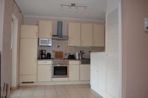 a small kitchen with white cabinets and appliances at FH Bernstein_CuE in Karlshagen