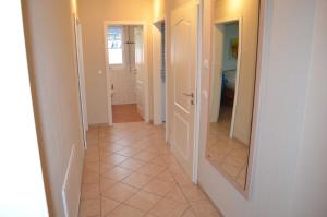 a hallway with a mirror and a tile floor at FH Bernstein in Ostseebad Karlshagen +5 photos