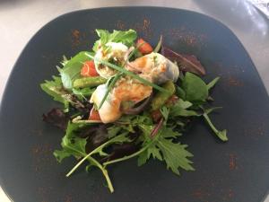 une assiette noire avec une salade de crevettes dessus dans l'établissement La Corbonniere, à Geneslay 22 autres photos