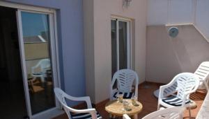 Pokój z białymi krzesłami i stołem w obiekcie One-bedroom flat 200m from the beach w mieście Almería