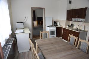 a kitchen with a wooden table and a dining room at Cottage Near The Forest in Kovač