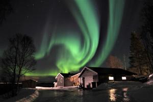 una imagen de la aurora boreal sobre una casa en House in the heart of the Lyngen Alps with Best view, en Lyngseidet