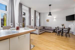 kuchnia i salon z kanapą i stołem w obiekcie Apartment Fiorentina w mieście Opatija