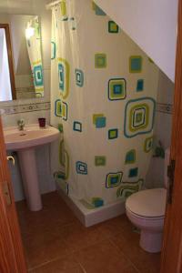 a bathroom with a shower curtain with a toilet and a sink at Casa Armando in Caleta de Sebo