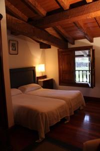 a bedroom with a large bed with a window at Mañuko Benta in Bermeo