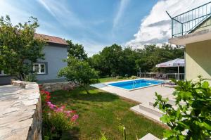 une arrière-cour avec une piscine et une maison dans l'établissement Apartments Srdanovic, à Omiš