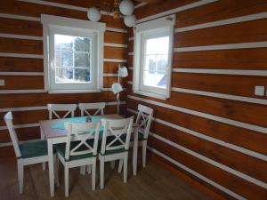 a dining room with wooden walls and a table and chairs at Apartmán Na Zlatníku in Zlatá Olešnice