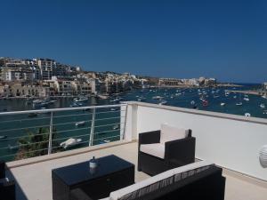 a balcony with a view of a harbor at Blue Skies Penthouse in Marsaskala