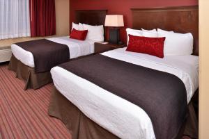 ウッドランドにあるBest Western Woodland Innのホテルルーム ベッド2台 赤い枕付