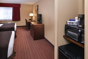 ウッドランドにあるBest Western Woodland Innのベッドとテレビが備わるホテルルームです。