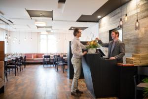 two men standing at a counter in a restaurant at Biohotel-Restaurant Rose in Hayingen