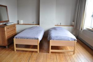 2 Betten in einem Zimmer mit einem Spiegel und einer Kommode in der Unterkunft W'allons nous dormir in Lüttich