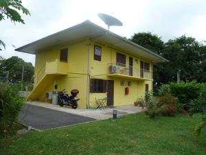 una casa amarilla con un satélite encima en Au Petit Canal Fleuri, en Rémire-Camp
