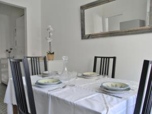 einen Esstisch mit einem weißen Tischtuch und einem Spiegel in der Unterkunft Ca' Nanopulin, Fronte Porto in Loano + 19 Fotos