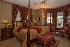 a bedroom with a large bed with red curtains at Sutherland House Victorian Bed and Breakfast in Canandaigua