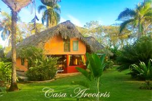 a small orange house with a thatch roof at Labellaventura in Las Galeras