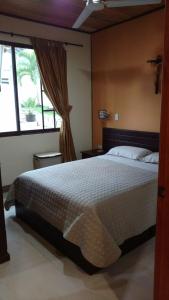 Un dormitorio con una cama grande y una ventana en La Casa de la Abuela, en Sucúa