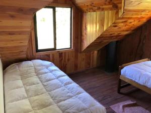 um quarto com uma cama e uma janela num camarote em Casa en el Lago Calafquen em Lican Ray