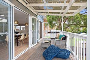 a screened porch with a couch and a table at Southern Belle Mollymook in Mollymook