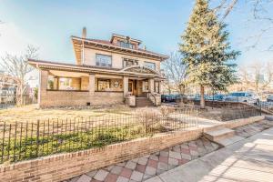 an old house with a fence in front of it at Ember Hostel in Denver