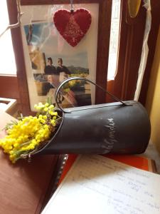 un vaso pieno di fiori gialli seduto su un tavolo di La Casa dei Nonni B&B a Scanno
