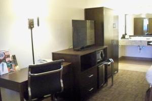 Habitación de hotel con TV, mesa y sillas en Sugarloaf Mountain Motel, en Bend