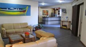 sala de estar con sofás, mesa y cocina en Apto Ponta das Canas - Floripa en Florianópolis