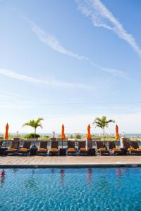 una piscina in un resort con sedie e palme di Ocean Club Hotel a Cape May