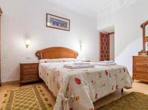 1 dormitorio con 1 cama grande y cabecero de madera en Carmen de la Lana en Granada