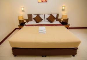 a bedroom with a large bed with two night stands at Prachuap Place Hotel in Prachuap Khiri Khan