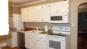 a kitchen with white cabinets and a white stove top oven at The Right Side Duplex in Charlotte