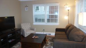 a living room with a couch and a tv at The Right Side Duplex in Charlotte