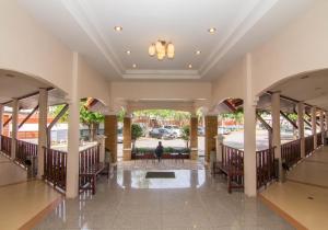 El vestíbulo de un hotel con mesas y sillas. en Prachuap Place Hotel, en Prachuap Khiri Khan