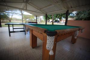 a pool table in a pavilion with a green at Quatro Estações Pesqueiro e Hotel Fazenda in Esmeraldas