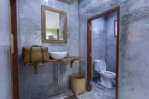 a bathroom with a sink and a mirror and a toilet at P's cottage บ้านพักในสวนสวย in Trang +34 photos