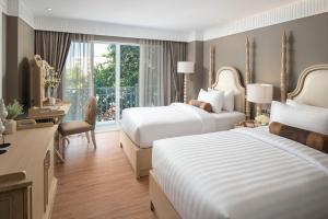 曼谷的住宿－Casa Vimaya Riverside，酒店客房配有两张床和一张书桌