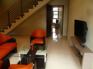 a living room with orange chairs and a television at Twin House in Kaliurang