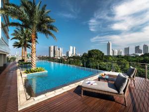 a swimming pool on a balcony with a city skyline at Oakwood Suites La Maison Jakarta in Jakarta