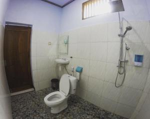 een badkamer met een toilet, een wastafel en een douche bij Danke Lodge in Labuan Bajo