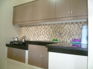 a kitchen with brown cabinets and a sink at Twin House in Kaliurang