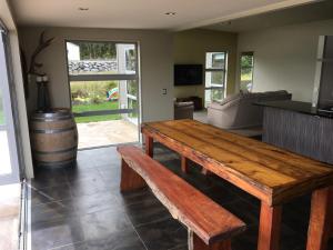 soggiorno con tavolo in legno e botte di Franz Josef Villa a Franz Josef